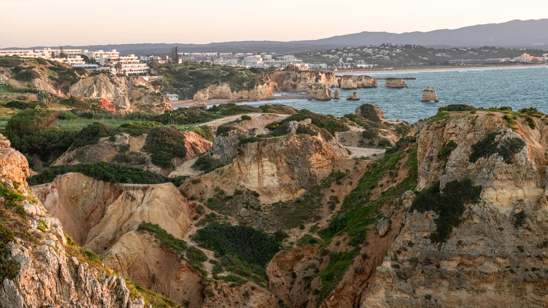 Limestone cliffs and sheltered coves at Ponta da Piedade, with Lagos along the coast
